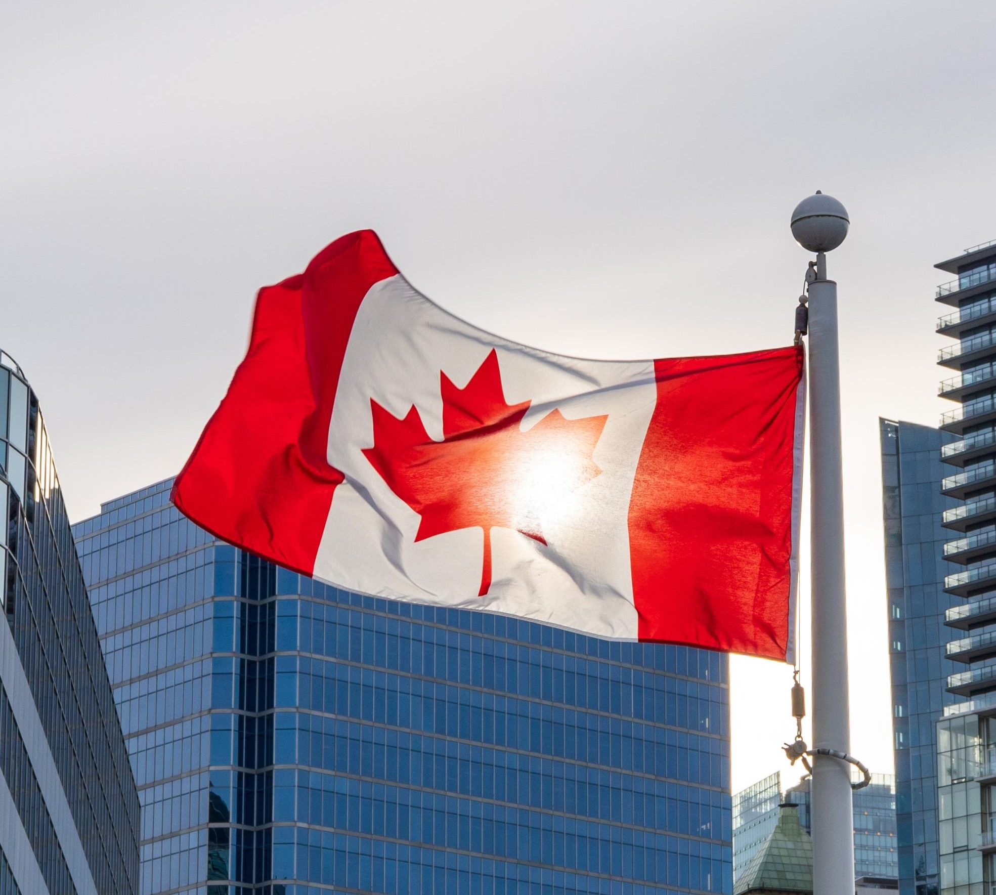 close-up-national-flag-canada-vancouver-city-skyscrapers-skyline-background